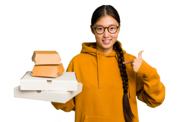 Young student asian woman holding a takeaway food isolated person pointing by hand to a shirt copy space, proud and confident