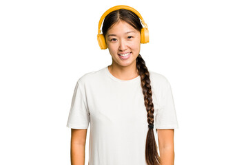 Young asian woman listening to music with headphones isolated happy, smiling and cheerful.