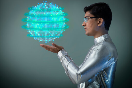 A man wearing silver, futuristic  clothes holding digital globe , future technology concept