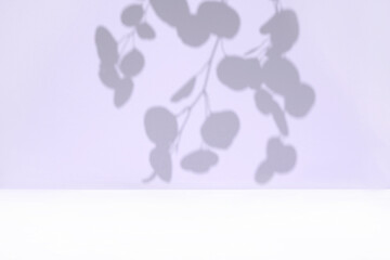 Plant shadows on violet color wall. Leaves shadow background. Branches, flowers and foliage on pastel studio background. Product presentation, Minimal mock up for advertising. Trendy Overlay effect