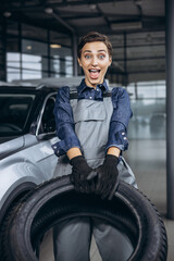 Naklejka premium Woman car mechanic changing tires at car service