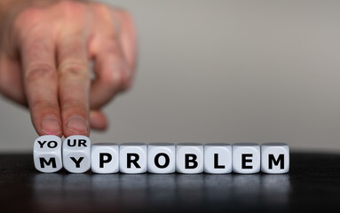 Hand turns dice and changes the expression 'my problem' to 'your problem'.