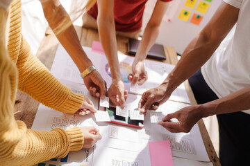 A UX design team is a confluence of user research, UX, UI design with layout paper on desk.
