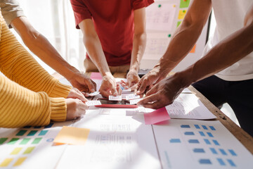 A UX design team is a confluence of user research, UX, UI design with layout paper on desk.