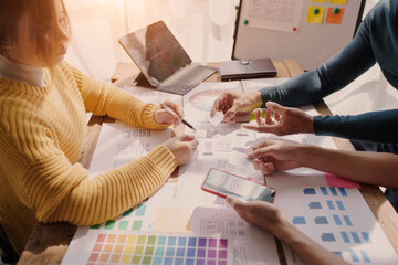 A UX design team is a confluence of user research, UX, UI design with layout paper on desk.