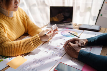 A UX design team is a confluence of user research, UX, UI design with layout paper on desk.