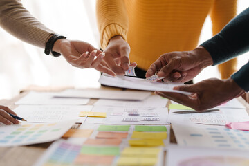 A UX design team is a confluence of user research, UX, UI design with layout paper on desk.