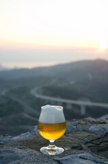 glass of lager beer in the mountains close up.  Sunset sky