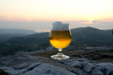 glass of lager beer in the mountains close up. 