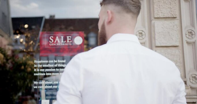 somebody is standing in front of a window with the sigm "SALE"