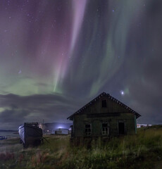 Northern Lights in the abandoned village of Dalniye Zelentsy. Rocks are two brothers. The Kola Peninsula. Russia