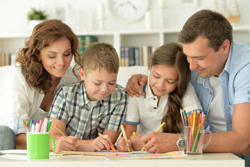 Happy parents and their children painting together