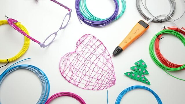 3d Pen. Printing with Colored Plastic Wire Filament. Child making a Christmas Three, Heart shape drawing with 3D pen. Artwork, Robotics. STEAM, STEM education. Modern Technologies. Study at home