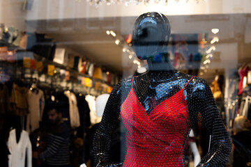 a black mannequin in a red dress in a shop window