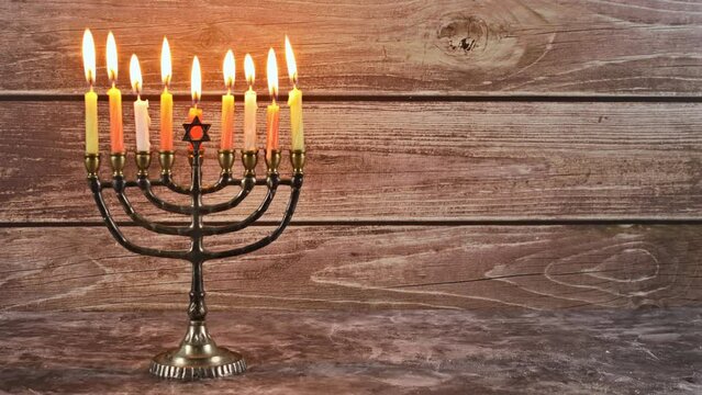 Jewish candle is lit in Menorah as part of the preparations for festival of Hanukkah its symbols