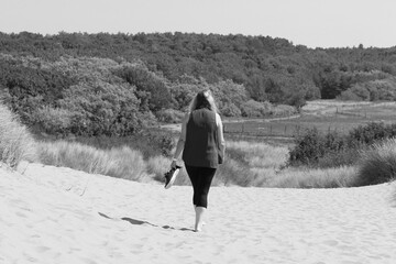 A woman exercising and walking through the Pine Woods and over the Sand Dunes at Formby in...