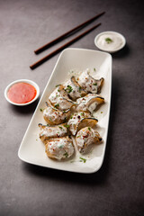 Tandoori momo, veg or non veg in red and cream sauce, served with sauce.  Nepal and Tibet recipe
