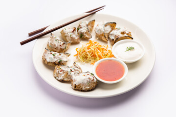 Tandoori momo, veg or non veg in red and cream sauce, served with sauce.  Nepal and Tibet recipe