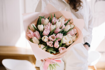 Very nice young woman holding beautiful bouquet of fresh pink and white tulip flowers, cropped photo, bouquet close up - 542687640