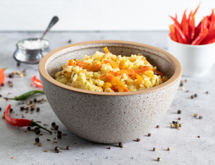 Delicious vegetarian pilaf with chickpeas in bowl on light concrete background