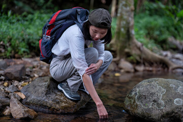 Backpack tourist travel hiking outdoor adventure use water stream from mountain washing hand
