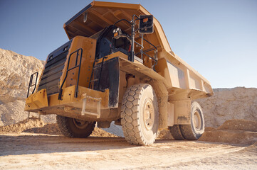 View from below of haul truck that is parked in the quarry at sunny daytime