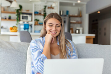 Nice beautiful lady work at the notebook sit down on the sofa at home - check on oline shops for...