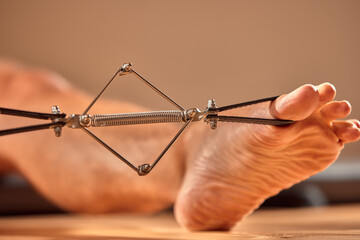 Pilates reformer workout exercises man at gym indoor.