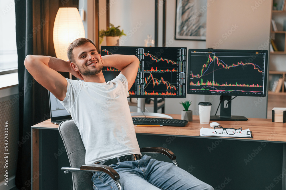 Poster taking a break. young stock broker is working in the office by using computer