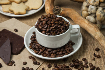 Fototapeta na wymiar Coffee with chocolate. Cup full of coffee beans and chocolate pieces