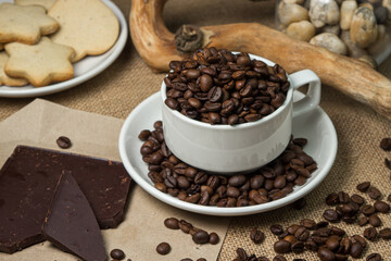 Coffee with chocolate. Cup full of coffee beans and chocolate pieces