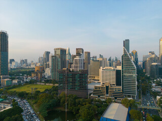 Aerial view modern office buildings and condominium park in Bangkok city downtown with sunset sky and clouds