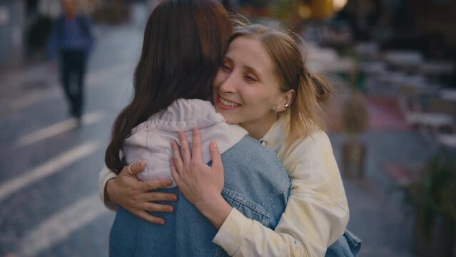 Lesbian couple are feeling happy standing in the old city town. Partner ugging her girlfriend. Feeling in love together. Woman relationships, lgbt concept