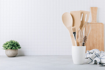 Kitchen utensils. Kitchen wooden tools and kitchenware. White modern kitchen interior background.