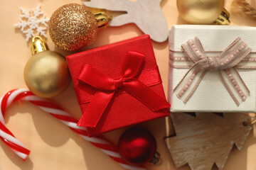 Small presents and various Christmas ornaments on neutral background. Top view.