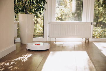 Robot vacuum cleaner does house cleaning close-up. Use of modern technology for cleaning. Front view