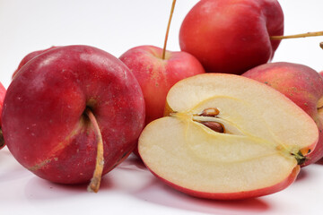 Small red Autumn Strawberry shaped Apple cut slice piece seed on white background