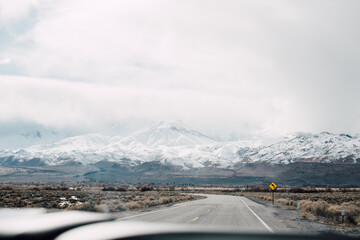 Dashboard view of open road and mountains in background, travel blogs first person point of view 