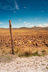 stick part of a fence, with a mountain of the peruvian andes in the background