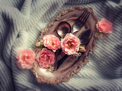 Pink Roses On Silver Tray With Antique Silverware, Light Blue Background For Contrast, Vintage Feel. Overhead Flat Lay.