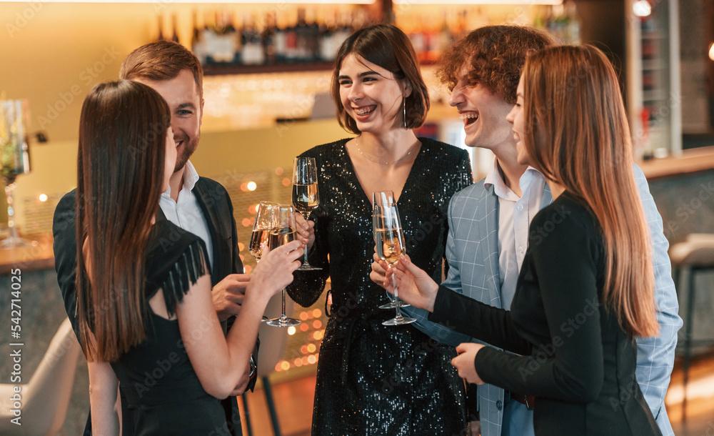 Wall mural conception of celebrating event. group of people in elegant clothes are in the restaurant