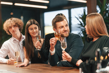 Friends are having fun. Group of people in elegant clothes are in the restaurant celebrating event