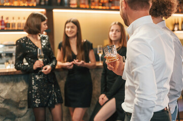 Talking and having fun. Group of people in beautiful elegant clothes are celebrating New Year indoors together