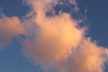 An orange cloud, illuminated at sunset