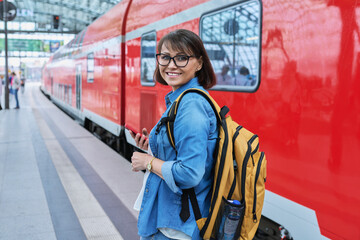 Woman waiting for railway public electric transport on platform of city station