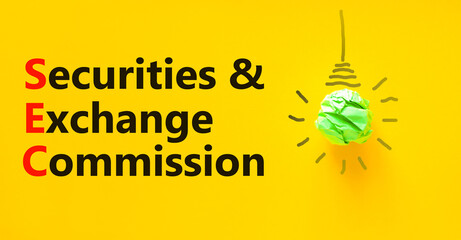 SEC securities and exchange commission symbol. Concept words SEC securities and exchange commission on a beautiful yellow background. Light bulb. Business SEC securities exchange commission concept.