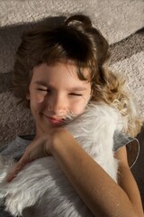 Happy child with a dog. Portrait of a girl with a pet. Jack Russell lying on her chest