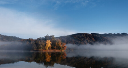 Fog falling down on the lake. Autumn, mountains and fog.