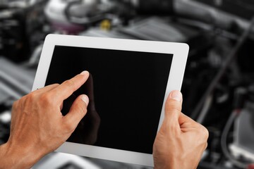 Mechanic worker with digital tablet on car background