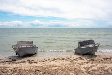 Fototapeta na wymiar Two old motor boats moored to the seashore
